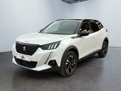 Le SUV blanc est garé dans une grande pièce équipée d'un ventilateur de plafond.