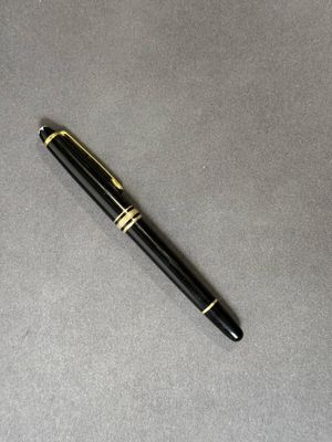le stylo est posé sur la table, à côté de la feuille