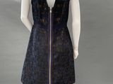 a mannequin wearing a black dress with a gold zipper