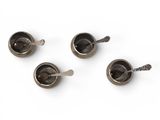 three spoons and a spoon rest on top of a white surface