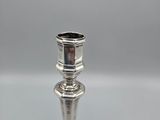 silver plated candle holder on a white surface with a gray background