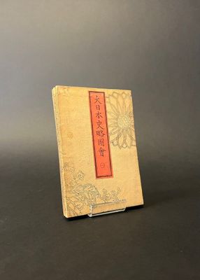 an old book sitting on top of a table next to a black table
