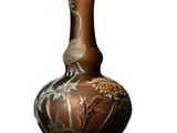 un vase avec un oiseau posé sur une table
