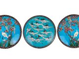 trois assiettes ornées d'oiseaux et de fleurs peints sur fond blanc