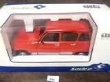 petite voiture rouge dans sa boîte, posée sur une moquette marron