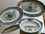 three plates and a pan on a stand on a table