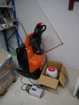 a small orange and black electric forklift in a room