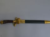 une épée dorée et noire sur un fond blanc