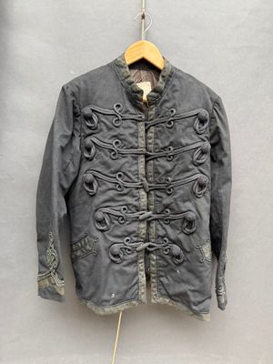 une vieille veste accrochée au mur à côté d'un cintre en bois