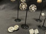a lot of silver jewelry on display on a black table