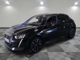 une voiture noire est garée dans une pièce au sol en damier