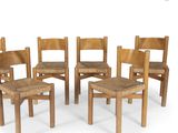 four wooden chairs with woven seats in a circle on a white surface