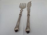 pair of silver plated utensils on a white surface