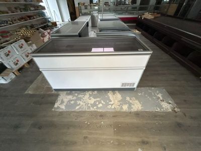 de nombreux plans de travail dans un magasin où le sol est encombré d'articles