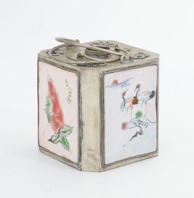 une petite boîte en argent ornée d'une image d'oiseaux