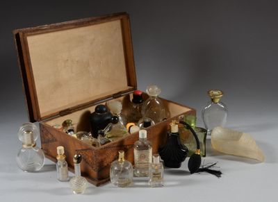a wooden box filled with bottles of perfume on a white surface