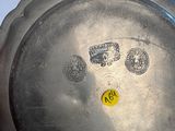 a silver plate with a yellow sticker on it