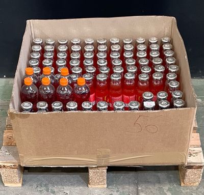 many bottles of soda in a box on a pallet