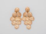 une paire de boucles d'oreilles en or sur fond blanc