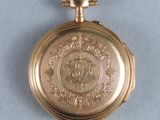 a gold pocket watch with a picture of a horse on it
