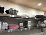 stainless steel shelves with pots and pans on them in a kitchen