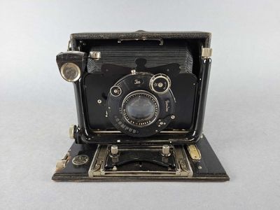 an old black camera sitting on top of a white surface