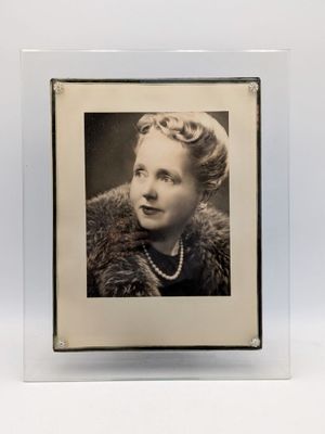 une vieille photo en noir et blanc d'une femme vêtue d'un manteau de fourrure