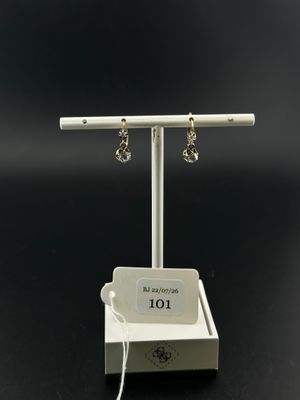 a white display stand with two pairs of earrings on it