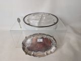 a silver plate with a spoon on it and a silver plate with a spoon on it