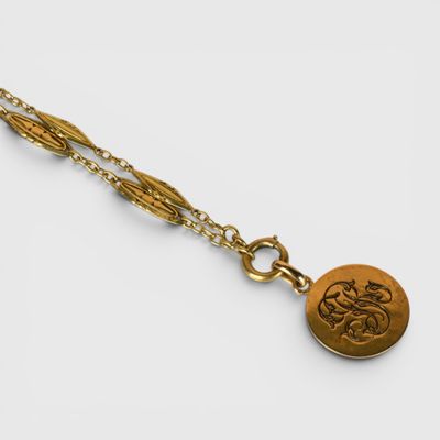 un gros plan sur un collier en or orné d'un médaillon