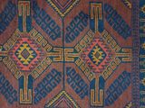 a close up of a blue and red rug on a wooden floor