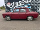 an image of a red car parked in front of a vintage sign