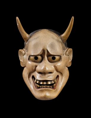 an image of a wooden mask with horns on a black background