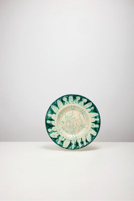 une assiette verte et blanche posée sur une table blanche