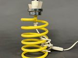 a close up of a yellow coil with a light on top of it