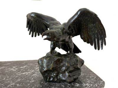 une statue représentant un aigle perché sur un rocher, les ailes déployées