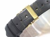 a close up of a black watch with a gold buckle