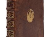 un vieux livre marron orné d'un emblème doré sur la couverture