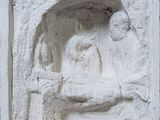 une image représentant un relief en pierre montrant un homme et une femme assis sur un banc