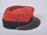 an old red and black hat is sitting on a white surface