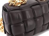 a close up of a black bag with gold chains on it