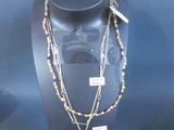 three necklaces on display in a glass case on a blue background
