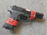 a gun with a red tape around it on the floor