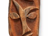 une image représentant une sculpture en bois représentant un visage sur fond blanc