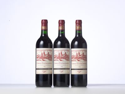 three bottles of red wine sitting on top of a table