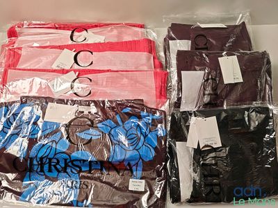 de nombreux t-shirts de différentes couleurs dans un sac en plastique posé sur une table