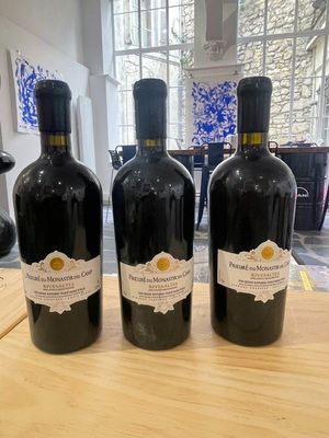 three bottles of wine sitting on top of a wooden table