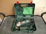 a green box with a drill and a cord in it