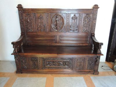 un banc en bois avec des sculptures dans une pièce