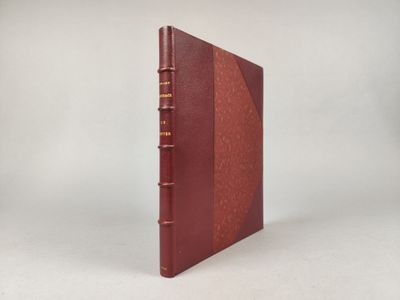 un livre rouge posé sur une table à côté d'un mur blanc